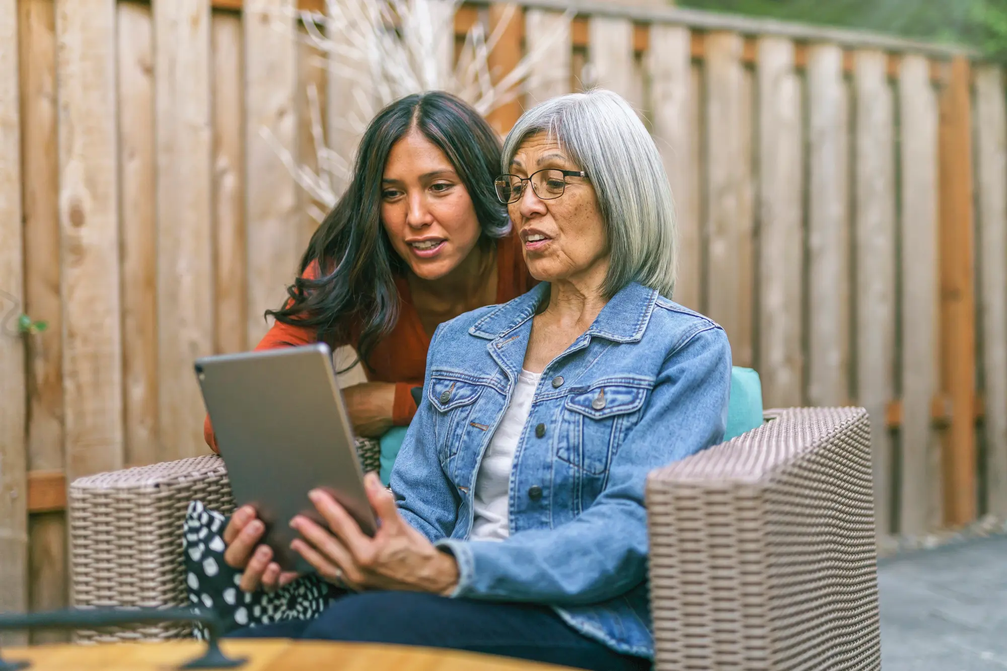 a woman with her mother looking at an ipad
