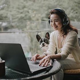 a girl and her dog looking at a laptop