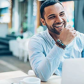 a man smiling at his laptop