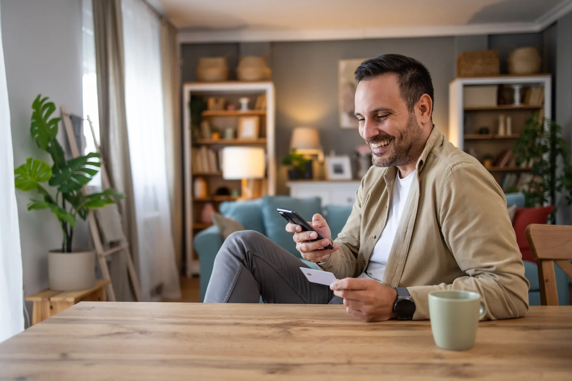 a man happily checking his finances on his phone