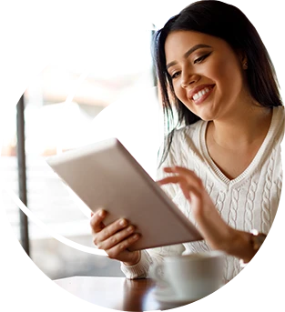 a girl in a white sweater looking at a tablet