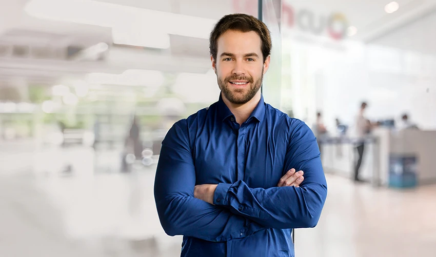 a man in a blue shirt outside of a blurry office building