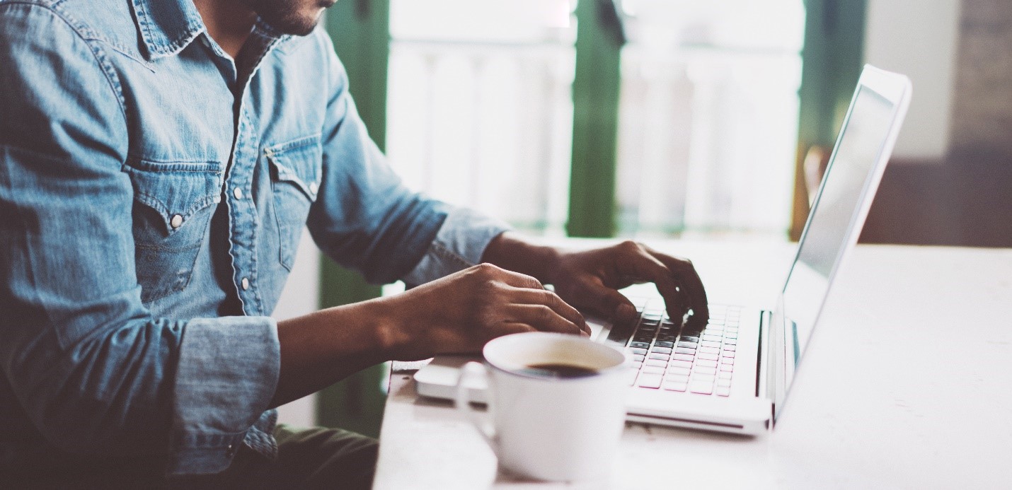 man at computer with a coffee