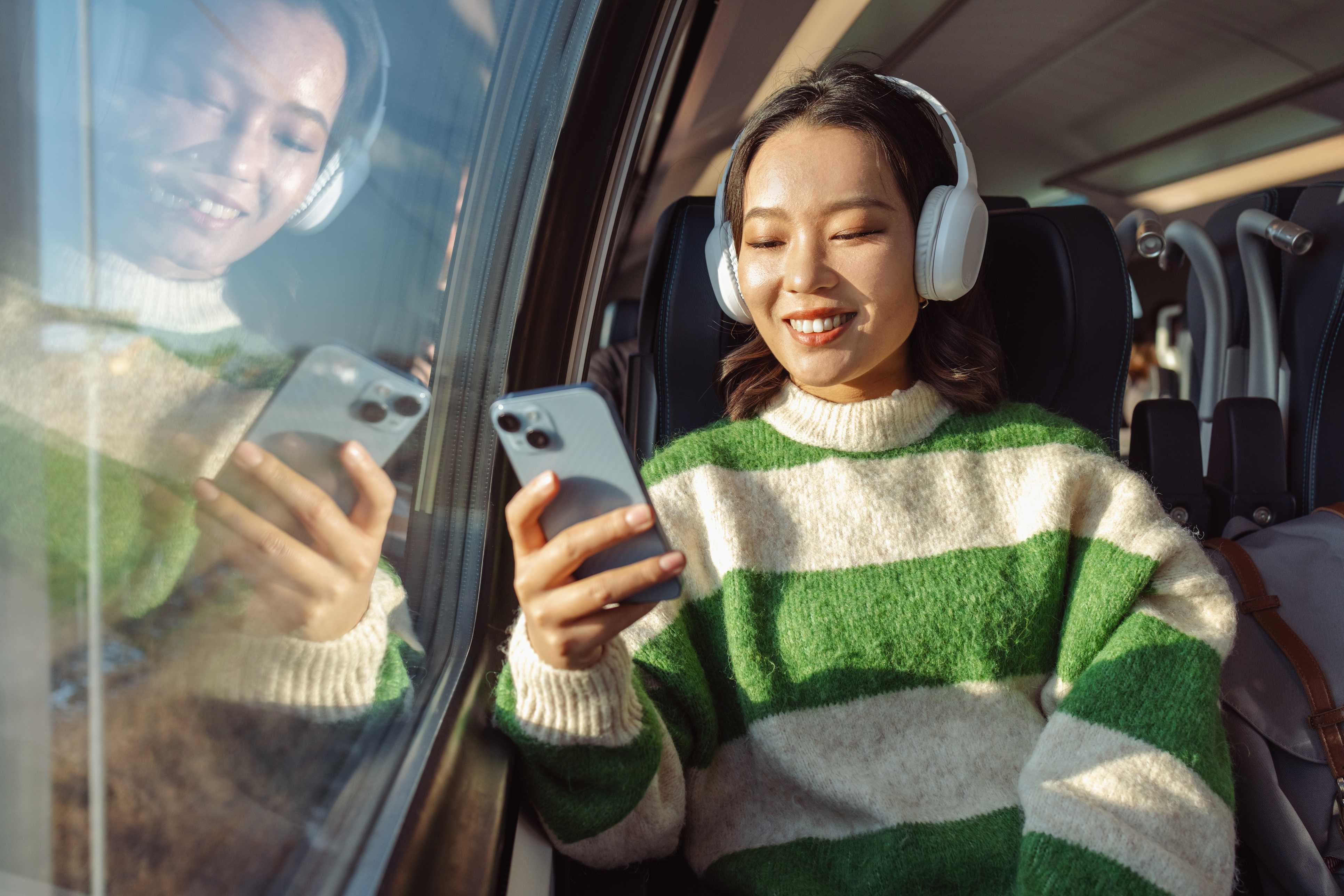 a girl looking at her phone on a train