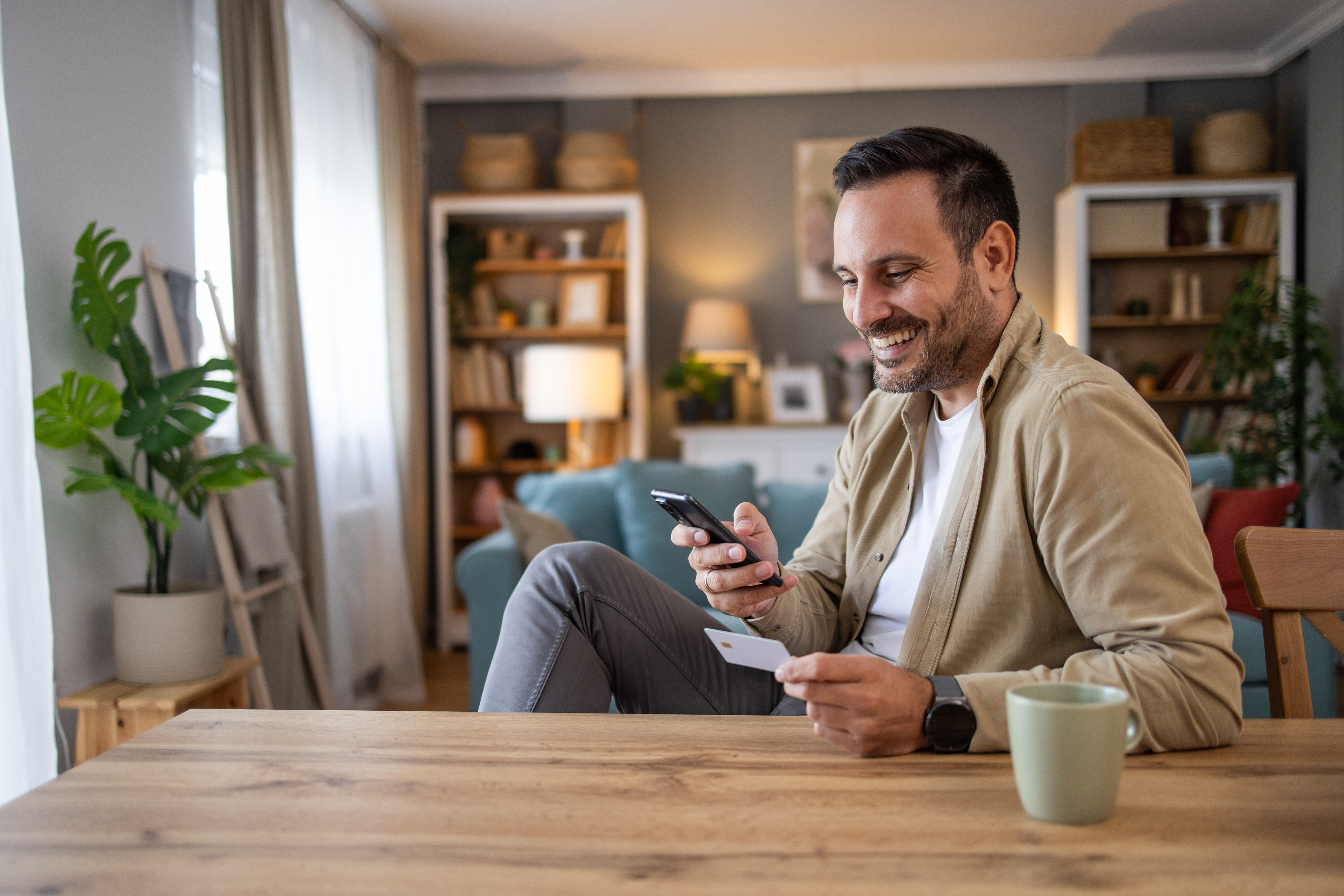 a man happily checking his finances on his phone