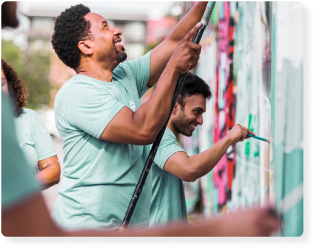 two men painting a mural on a wall